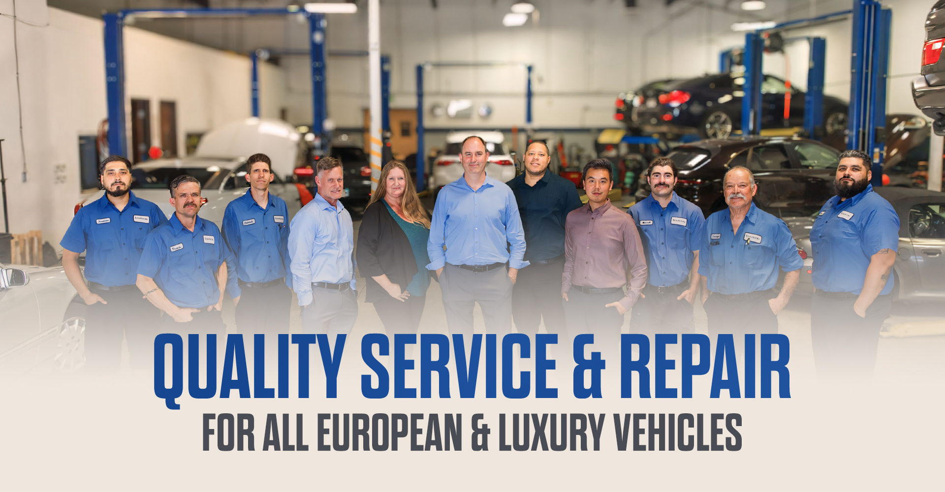 The team at Star Motors stands in their clean and spacious auto repair bay.