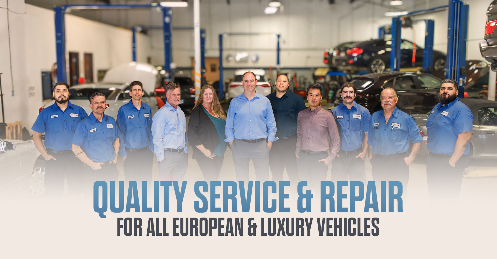 The team at Star Motors stands in their clean and spacious auto repair bay.